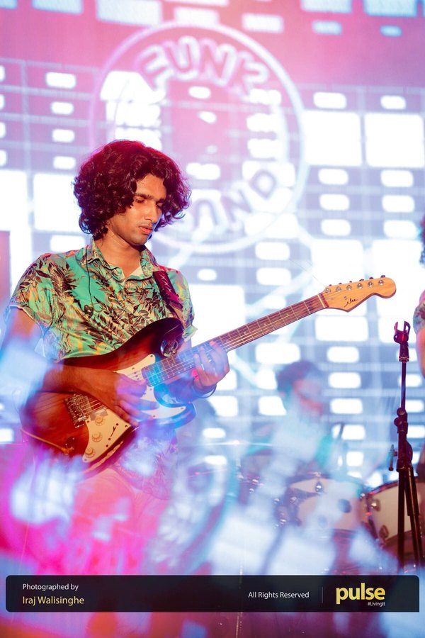 Nathan Perera playing electric guitar with Funk Island