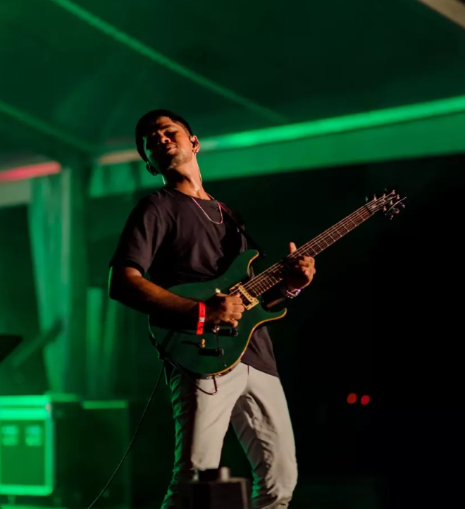 Poori Hennayake playing electric guitar on stage with Funk Island