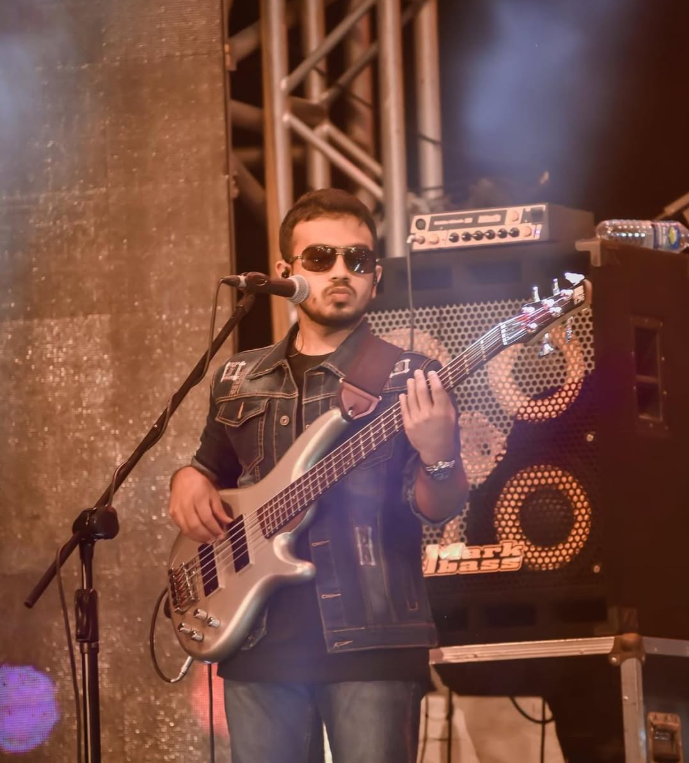 Venuk Pesara playing bass guitar on stage with Funk Island